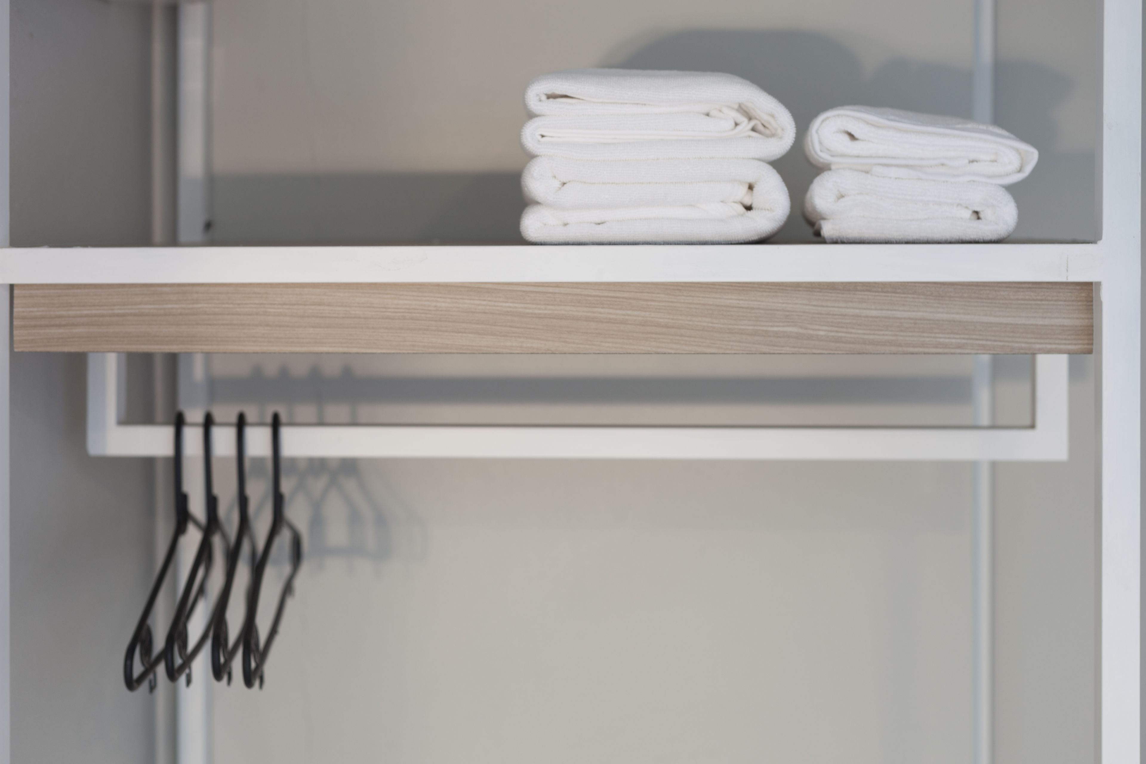 A bathroom with a towel rack holding multiple towels.