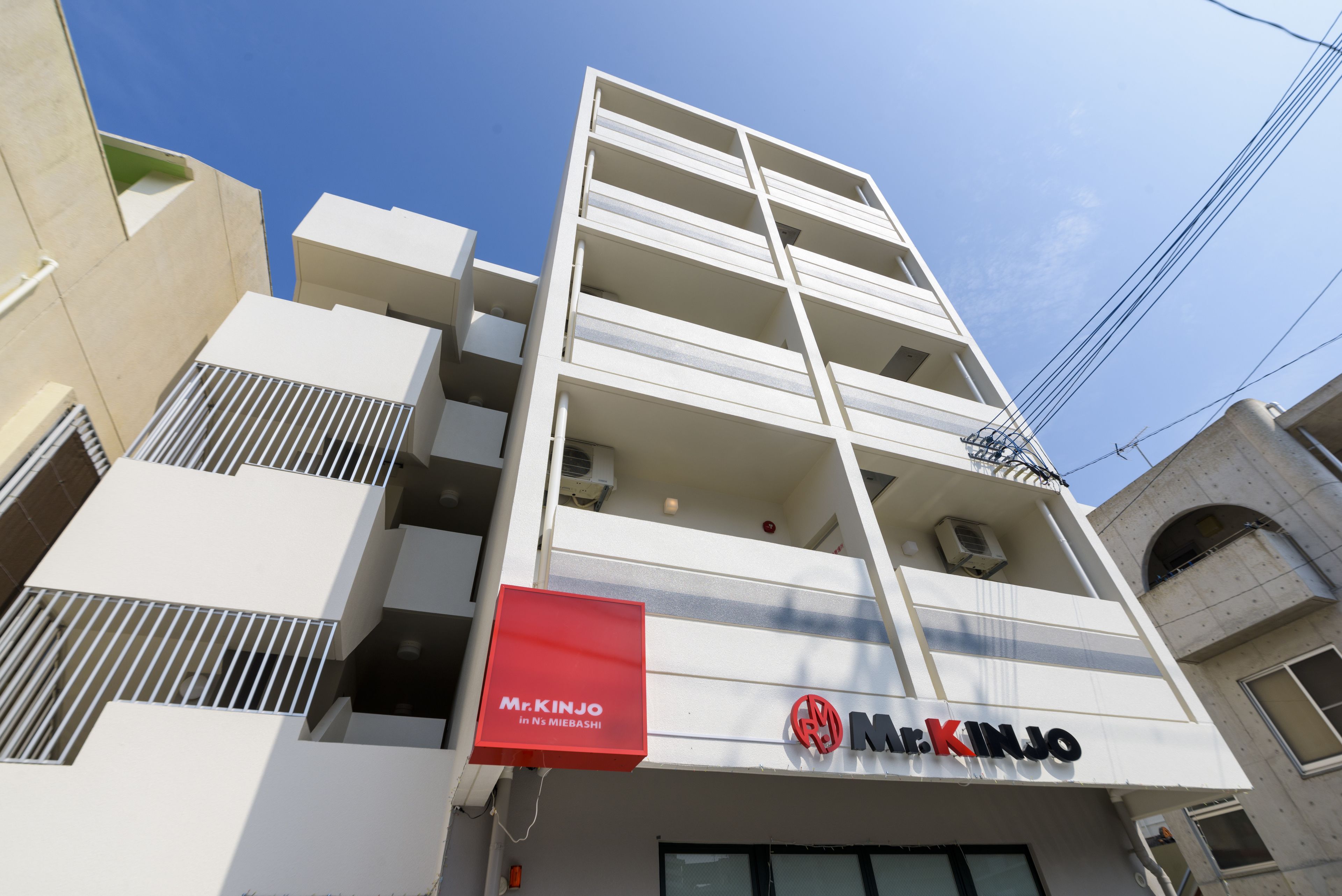 A multi-story building with a prominent Mr. Kinjo sign on the facade.
