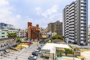 A multi-story building with a modern design, featuring balconies and a flat roof. - Mr.KINJO in Nica’s Makishi Station (Naha)