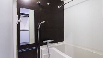Une salle de bain moderne avec un meuble-lavabo en bois foncé, une baignoire blanche et une douchette à main.