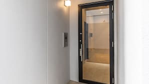En smal hall med en dörr som leder in till ett rum.