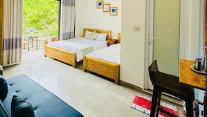 A hotel room with two wooden beds, a sofa, a desk, and a large window with curtains. - Shark Hotel - Hostel (Hue)