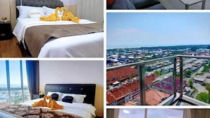 A hotel room with a bed, a sofa, a dining area, and a balcony with a city view. - Sekinchan Seaview Homestay (Sekinchan)