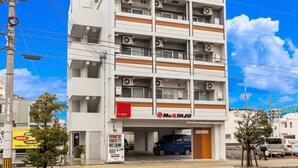 A multi-story building with a Mr. Kinjo sign, air conditioning units, and a parking garage. - Mr.KINJO in UCHIDOMARI (Ginowan)