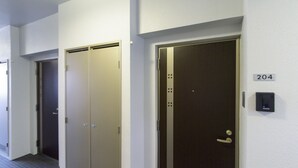 A hallway with three doors, one marked with the number 204. - Mr.KINJO in UCHIDOMARI (Ginowan)