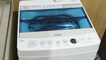 Una lavadora Haier blanca con puerta transparente, panel de control con varias opciones y etiqueta de capacidad de 4.5 kg.