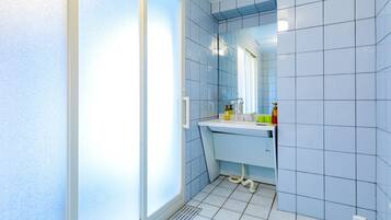 A bathroom with a white sink, mirror, and tiled walls.
