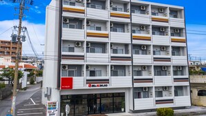 A multi-story hotel with a modern design, featuring balconies and air conditioning units. - Mr.KINJO in ISHIKAWA inter (Uruma)