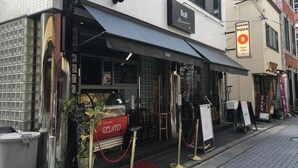Una heladería con toldo negro y un letrero que indica que sirve helado y café.
