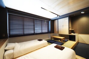A compact hotel room with two single beds, a small table, and a bench. - Yumoto Station Hotel MIRAHAKONE (Hakone)