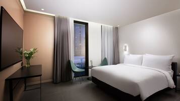 Een moderne hotelkamer met een groot bed, een bureau en een stoel.