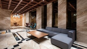 Un vestíbulo moderno con un sofá modular, una mesa de centro de madera y un suelo con diseño.