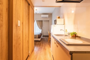 Quarto casal básico | Cozinha americana privada | Geladeira, micro-ondas, cooktop, chaleira elétrica