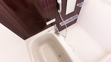 A white bathtub with a showerhead and a faucet.