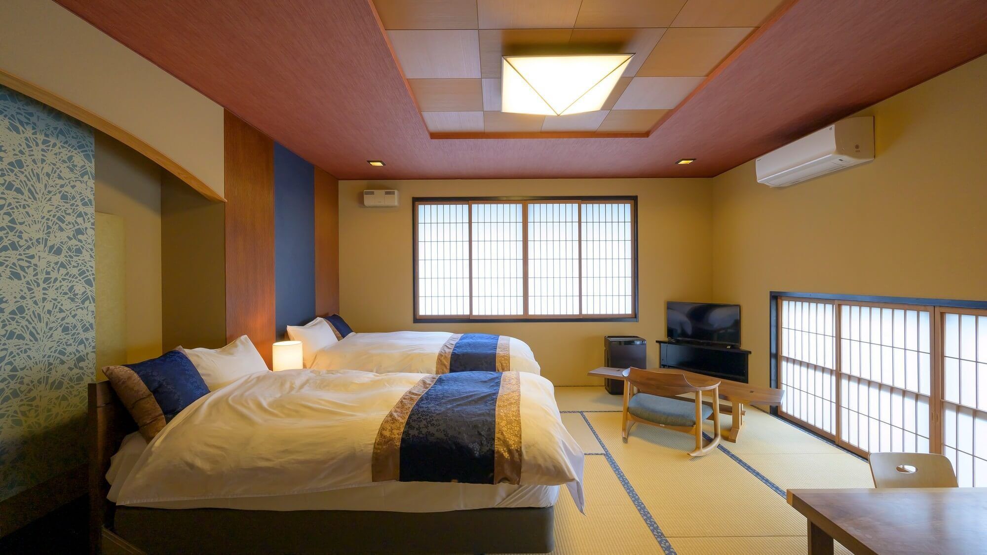 Une chambre d’hôtel avec un lit, une télévision, une petite table et une fenêtre.