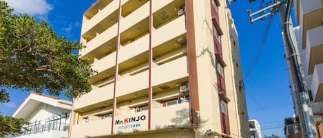 A multi-story building with a sign reading "Mr. Kinjo Violette".