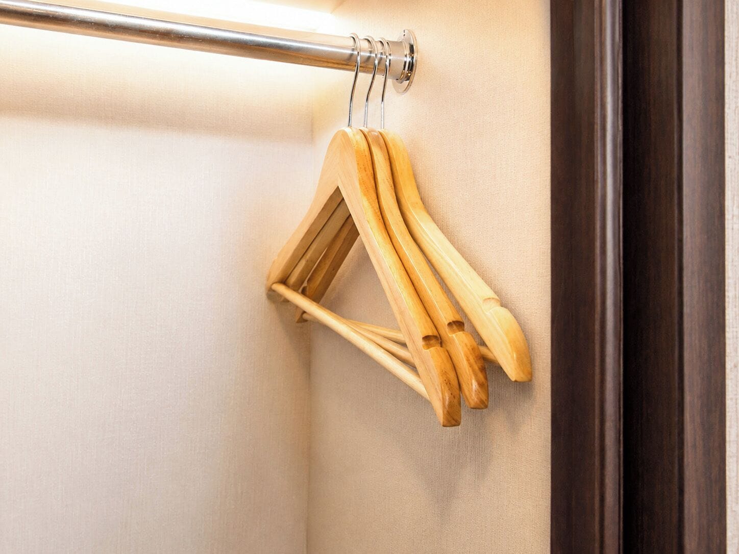 A metal rod with wooden hangers attached to it.