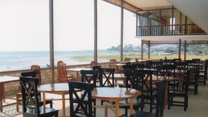 A restaurant with outdoor seating overlooking a body of water.