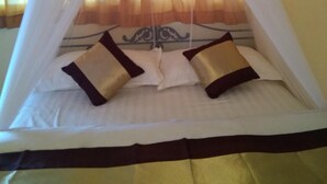 A bed with a canopy, two pillows, and a decorative headboard.