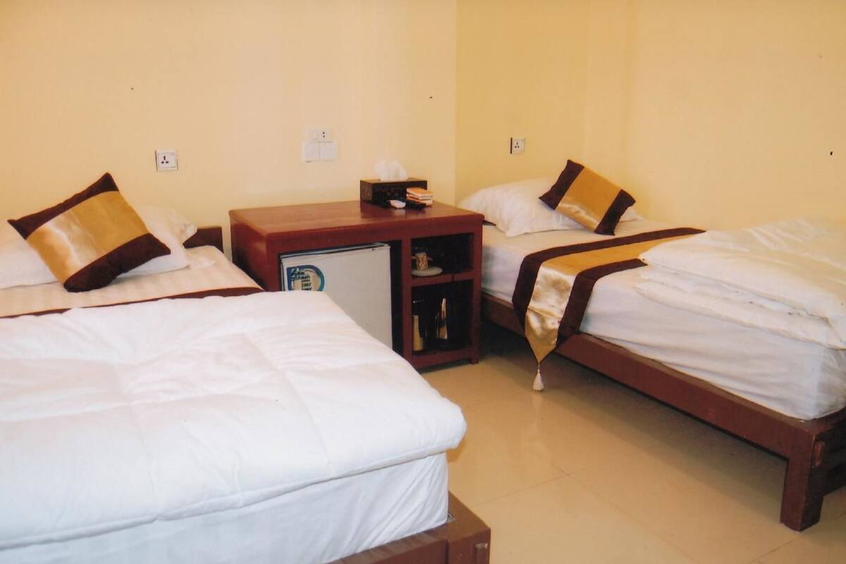Une chambre d’hôtel avec deux lits, un petit bureau et un minibar.
