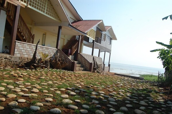 A beachfront property with a stone pathway leading to a wooden staircase, a balcony, and a view of the sea. - Pekon Princess Resort (Pekon)