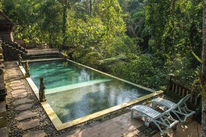 Una piscina al aire libre, tumbonas