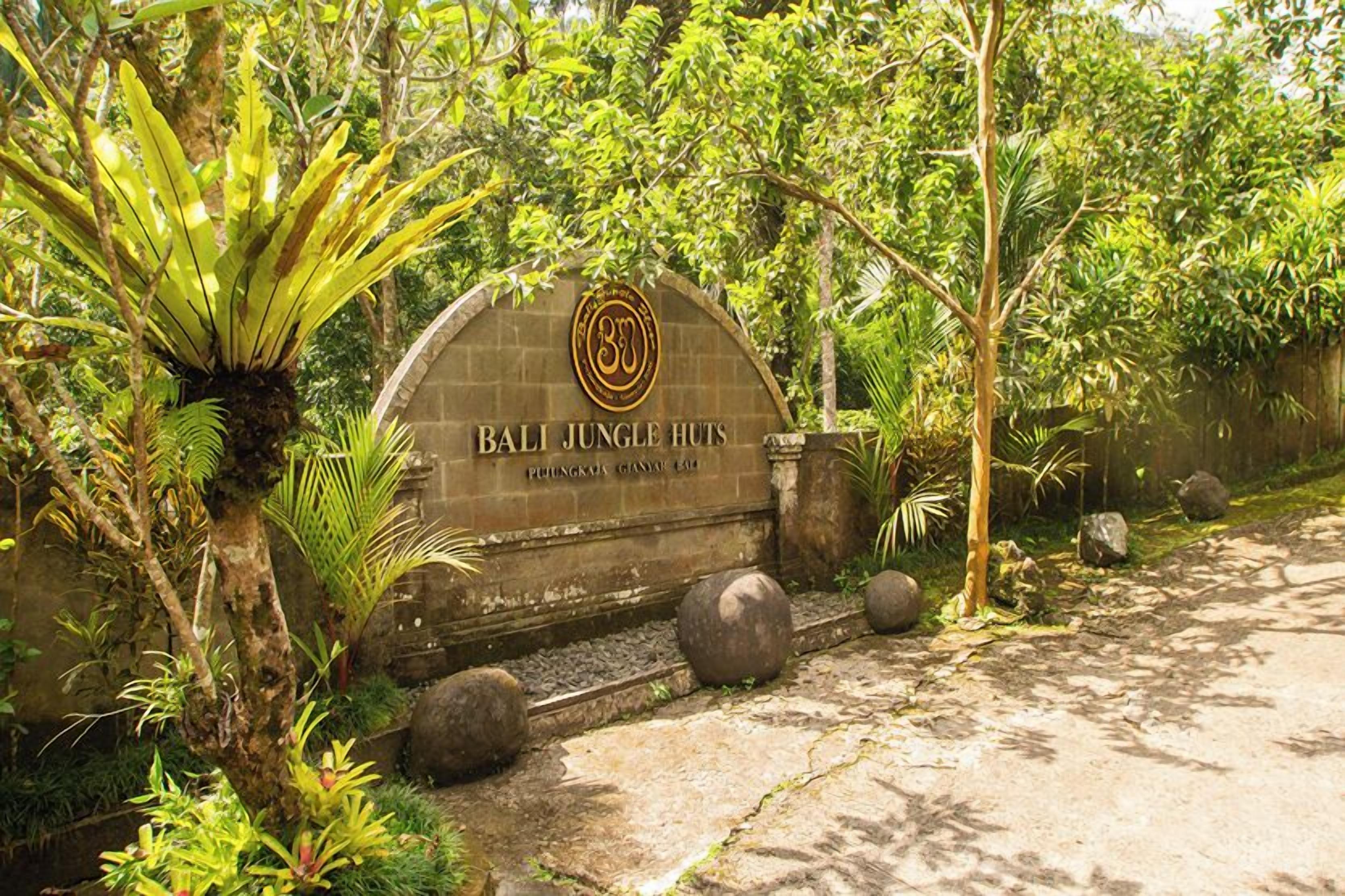 A stone archway with the inscription "Bali Jungle Huts" and a logo.