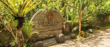 A stone archway with the inscription "Bali Jungle Huts" and a logo.