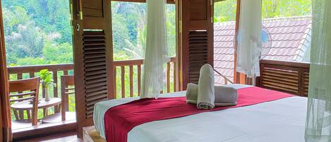A wooden room with a bed, a table, and chairs.