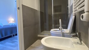 Une salle de bain moderne avec une grande baignoire, des toilettes et une douche à parois de verre.
