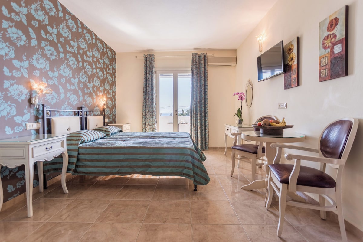 A bedroom with a bed, bedside tables, a desk, and a chair.