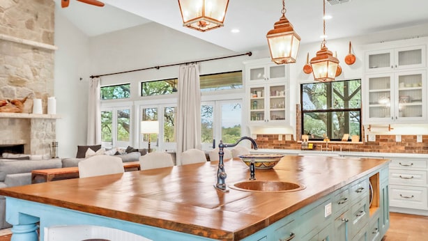 A spacious kitchen with a large island, white cabinetry, and pendant lighting. - 4BR Canyon Lake Retreat with New Private Pool & Outdoor Living (Canyon Lake)