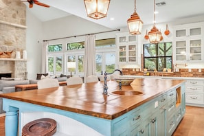 A spacious kitchen with a large island, white cabinetry, and pendant lighting. - 4BR Canyon Lake Retreat with New Private Pool & Outdoor Living (Canyon Lake)