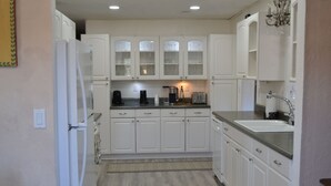 A kitchen with white cabinets, a refrigerator, a coffee maker, a toaster, and a sink. - Near town & Golf, Sleeps 15, 3,300sqft, 1.9 Acres, 6BR w/4Kings, Game Room, HVAC (Williams)