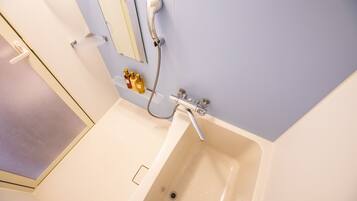 A bathroom with a bathtub, a shower, and a mirror.