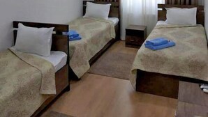 A hotel room with two single beds, a TV mounted on the wall, and a window with curtains. - Magistral (Urtaaul)