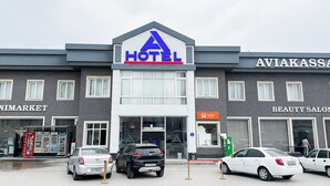 A hotel with a prominent 'HOTEL' sign, adjacent to a 'MINIMARKET' and a 'BEAUTY SALON'. - Magistral (Urtaaul)