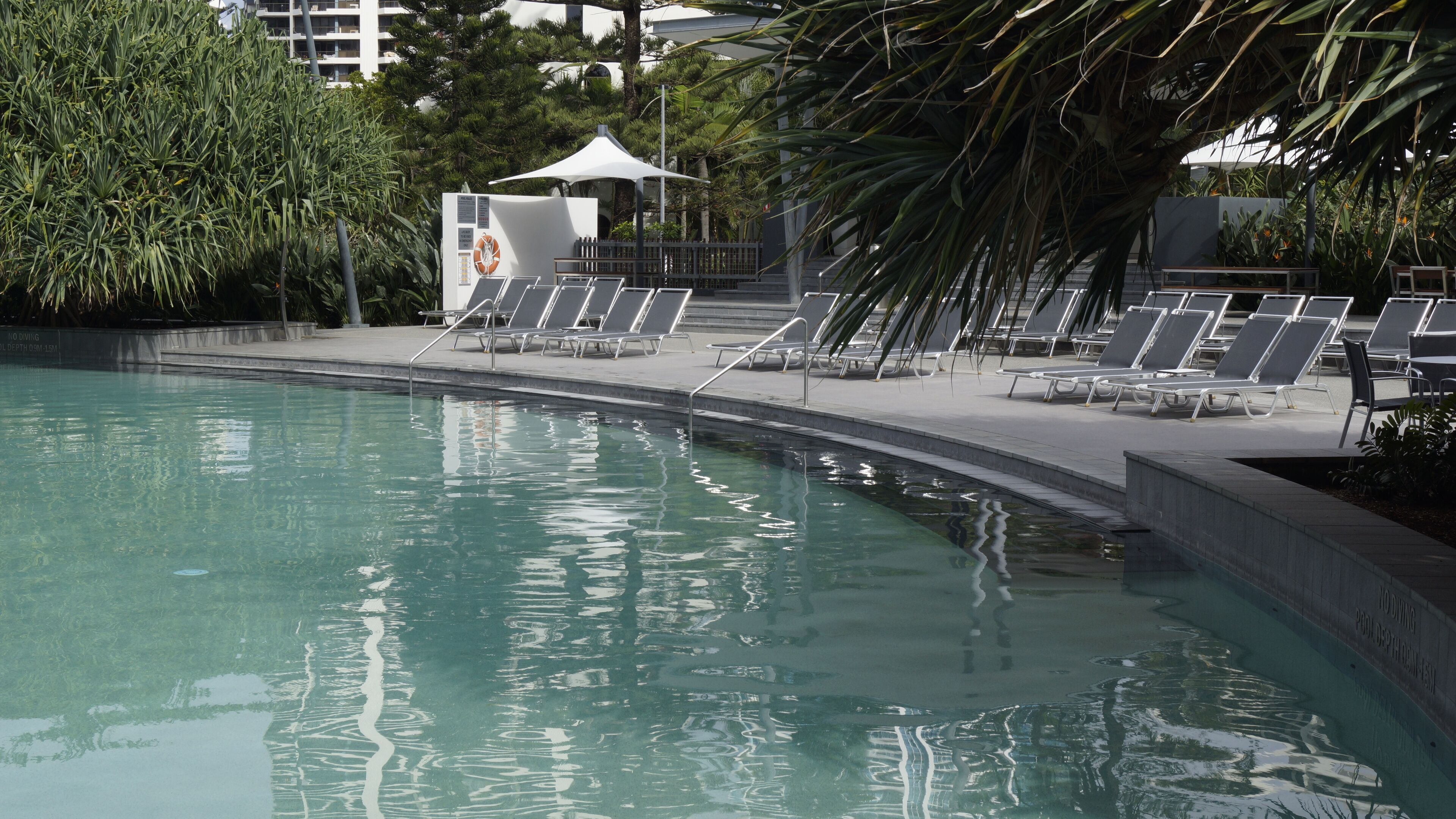 A pool area with lounge chairs and a lifeguard station.