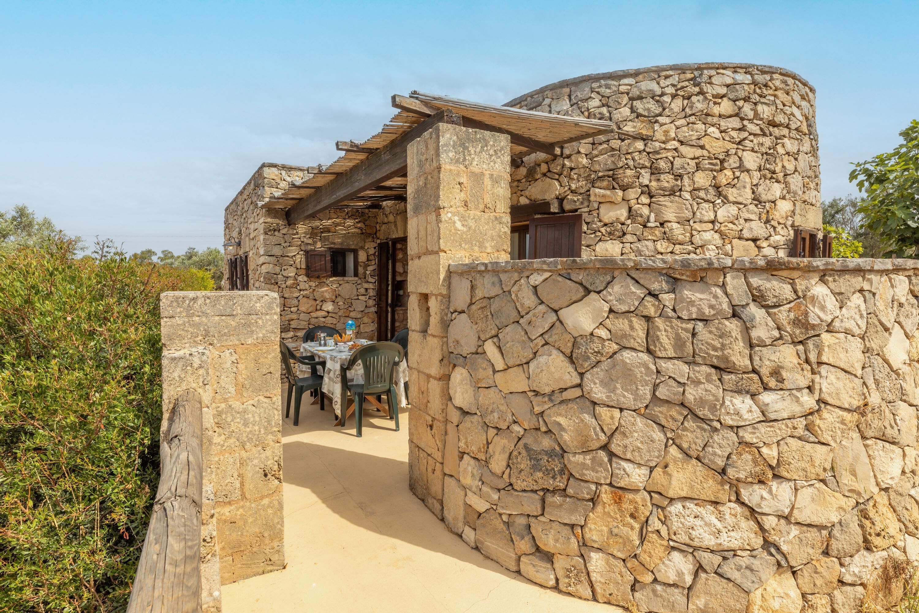 Un edificio de piedra con un espacio de asientos al aire libre cubierto.