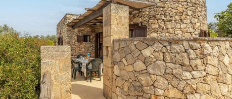 Un edificio de piedra con un espacio de asientos al aire libre cubierto.