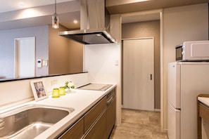 A modern kitchen with a stainless steel sink, a built-in oven, and a microwave. - Mr.KINJO in PREMIUM TERRACE CHATAN (Chatan)