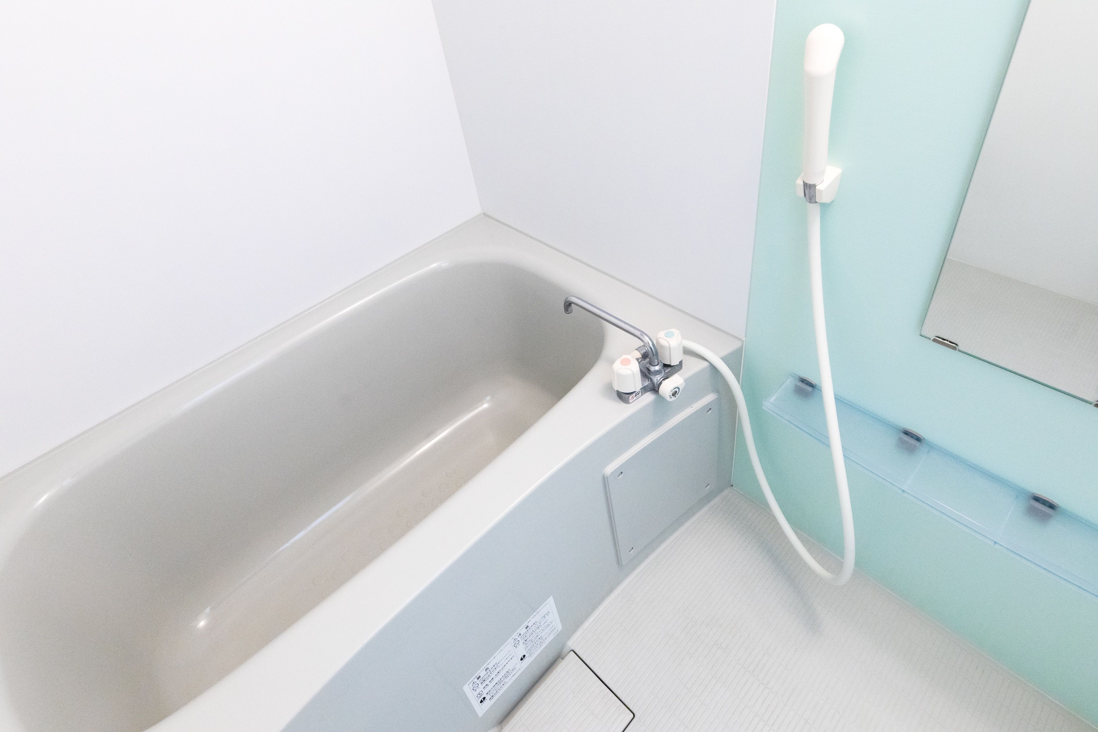 Une salle de bain moderne avec une baignoire, une douche et un miroir.