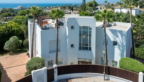 Un bâtiment moderne doté d’un toit incurvé, de nombreuses fenêtres et offrant une vue sur la mer.