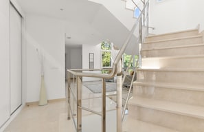 Un intérieur moderne avec un escalier, un design minimaliste et une vue sur l’extérieur.