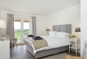 Ground floor: Bedroom with king size bed and en-suite bathroom with shower, and french doors to veranda