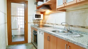 A kitchen with a granite countertop, stainless steel sink, and a microwave. - El Rincon del Golf III - Isla Canela Golf GRHIII99P99 (Isla Canela)