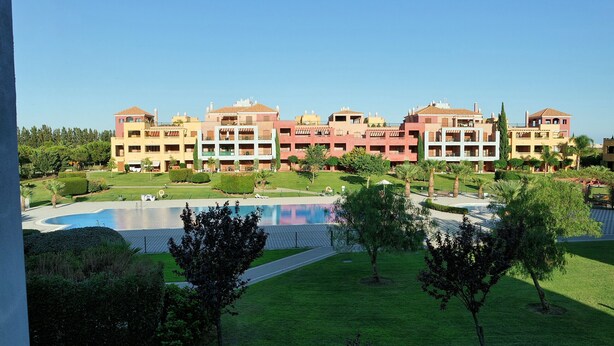 A hotel with multiple buildings, a swimming pool, and well-maintained lawns. - El Rincon del Golf III - Isla Canela Golf GRHIII99P99 (Isla Canela)