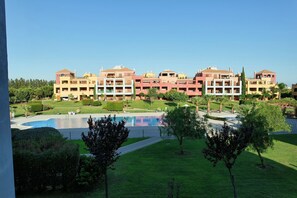 A hotel with multiple buildings, a swimming pool, and well-maintained lawns.