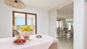 A dining area with a table set for a meal, a bottle of champagne, and a bowl of fruit. - CAN SAL - Villa with private pool in and free WiFi in Ariany (Ariany)