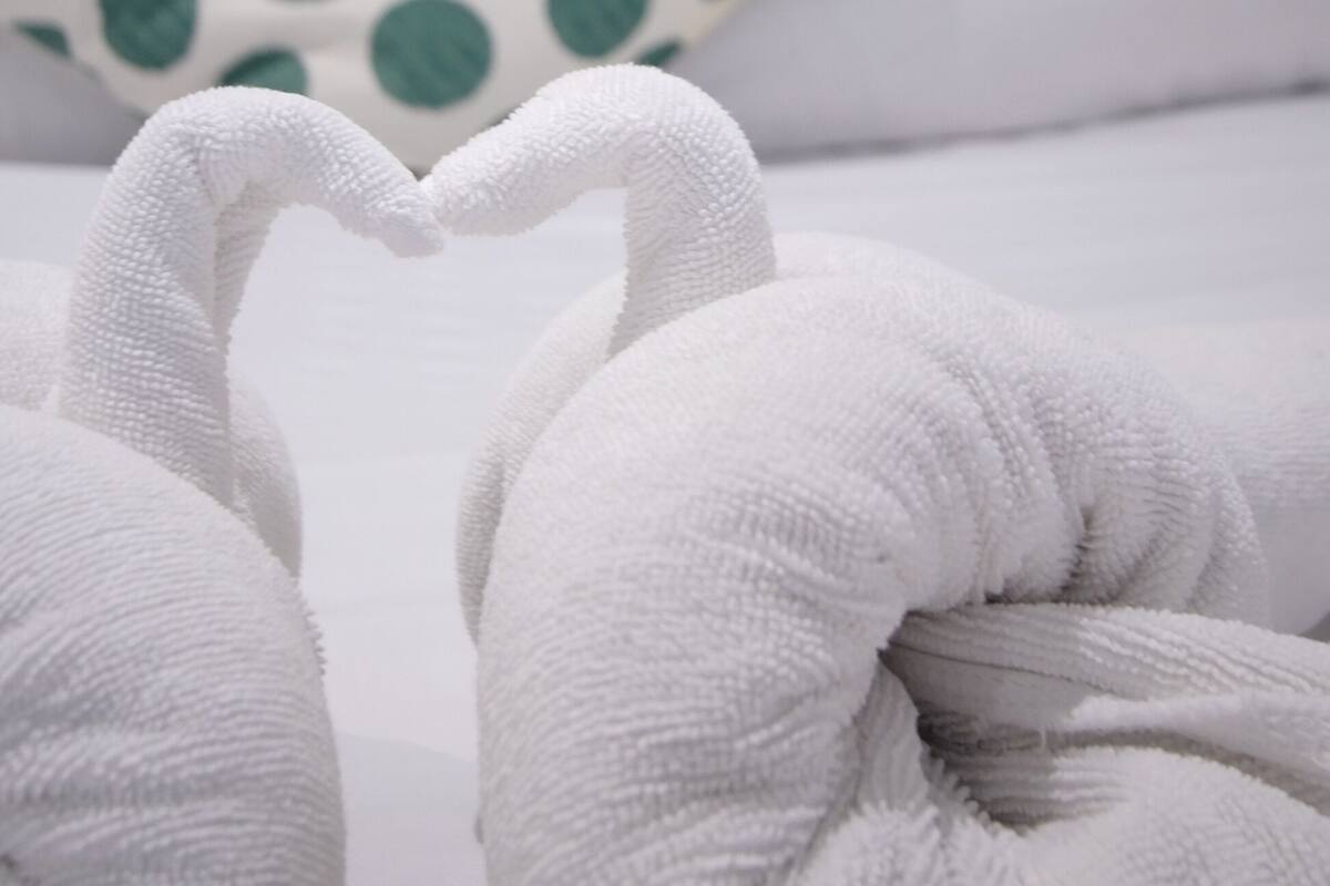 A bed with white pillows and a green polka dot pillow.